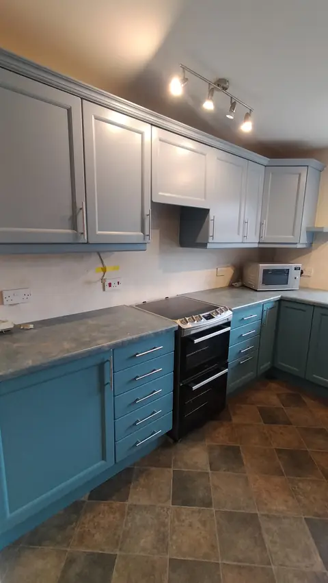 Grey wall units with teal base cabinets